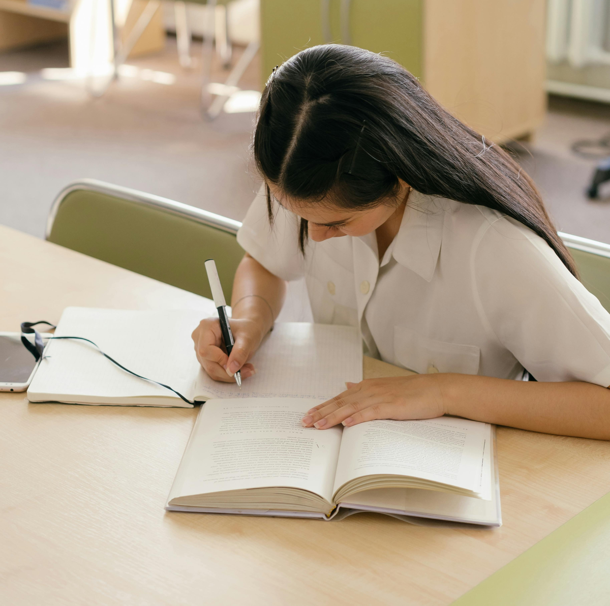 una joven estudiando en una biblioteca